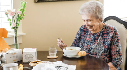 Elderly woman eating soup