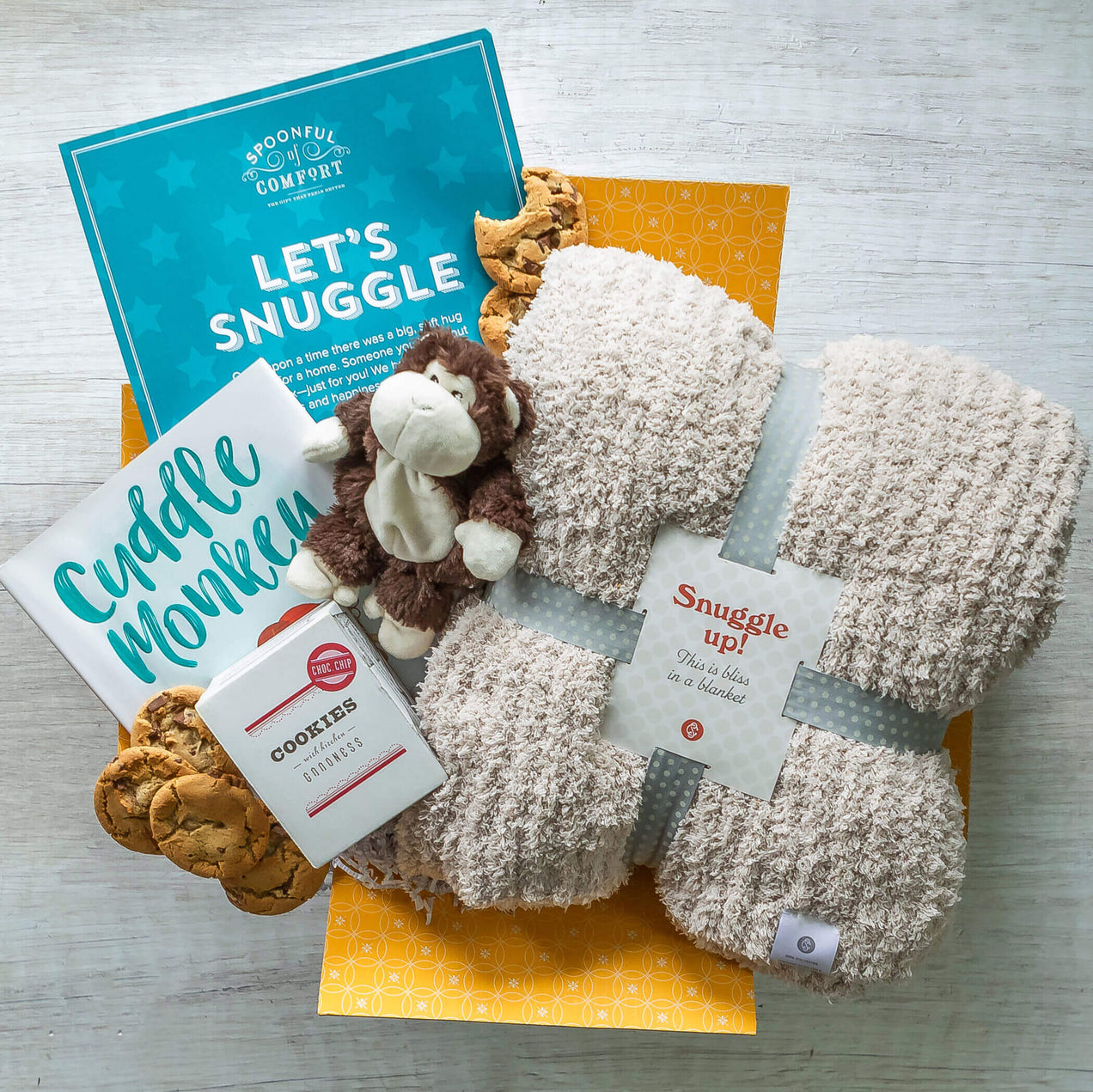 Cookies and Cuddles Care Package. Image shows warmable plush monkey, cuddle monkey book words by Blake Liliane Hellman Pictures by Chad Otis. Surrounded by cookies and insert that says "let's Snuggle"